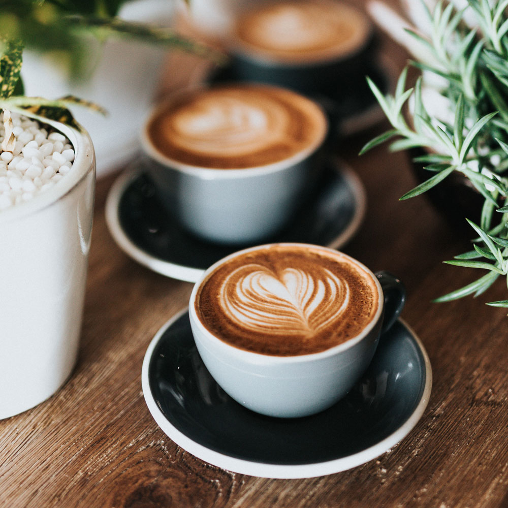 A coffee with a love heart pattern in the froth with chocolate powder